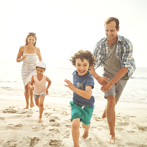 Photo of a family of four playing on the beach